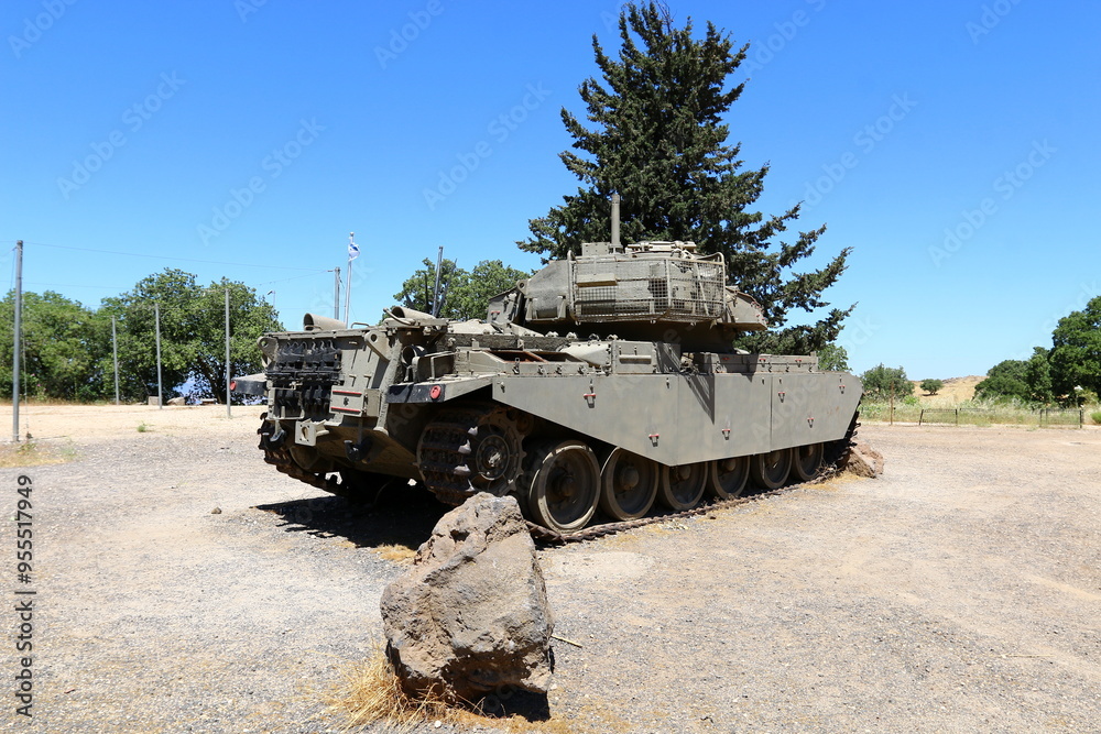 An old tank stands on the side of the road. An old tank stands on the side of the road.