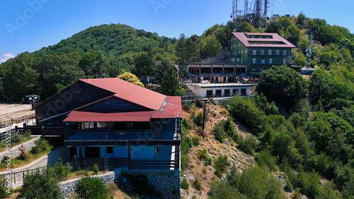 Abandoned ski resort buildings overlooking green mountain forest