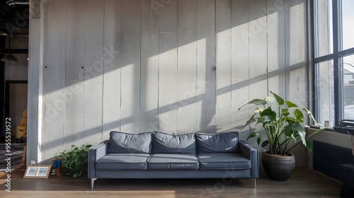 A modern industrial-style living room with a grey sofa against a concrete stucco wall. The room has high ceilings and is filled with natural light.  photo