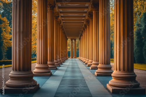 Architectural old columns create a stunning perspective in a sunlight garden with autumn foliage