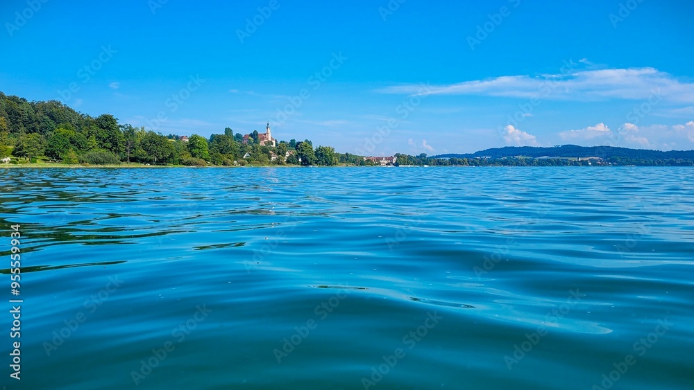 View of the lake Constance and Birnau basilica in Germany from the water on a sunny summer day. View of the lake Constance and Birnau basilica in Germany from the water on a sunny summer day.