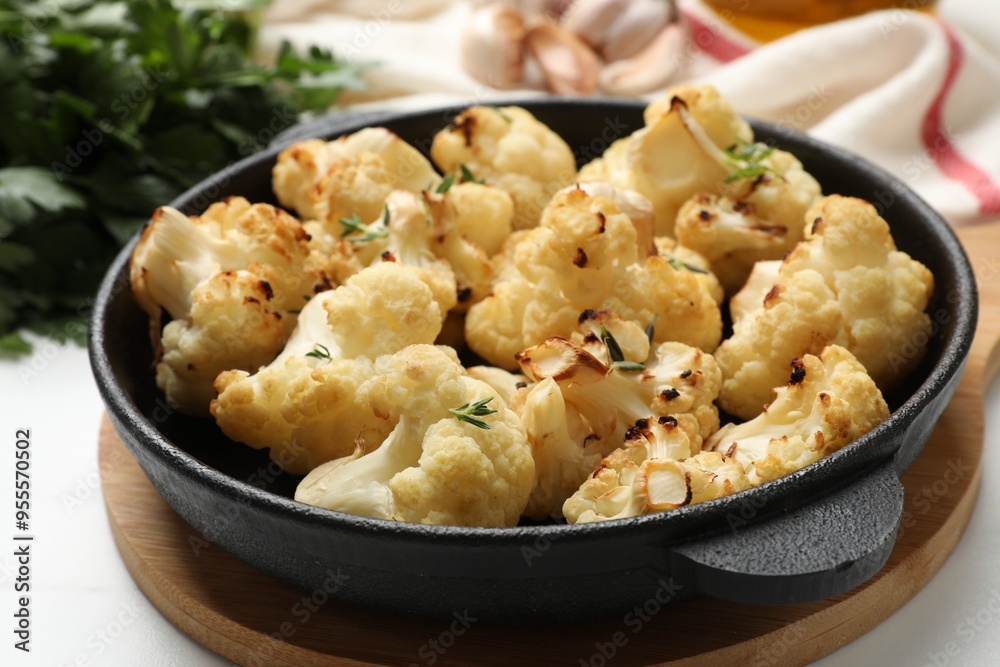 Tasty baked cauliflower in baking pan on white table, closeup Tasty baked cauliflower in baking pan on white table, closeup