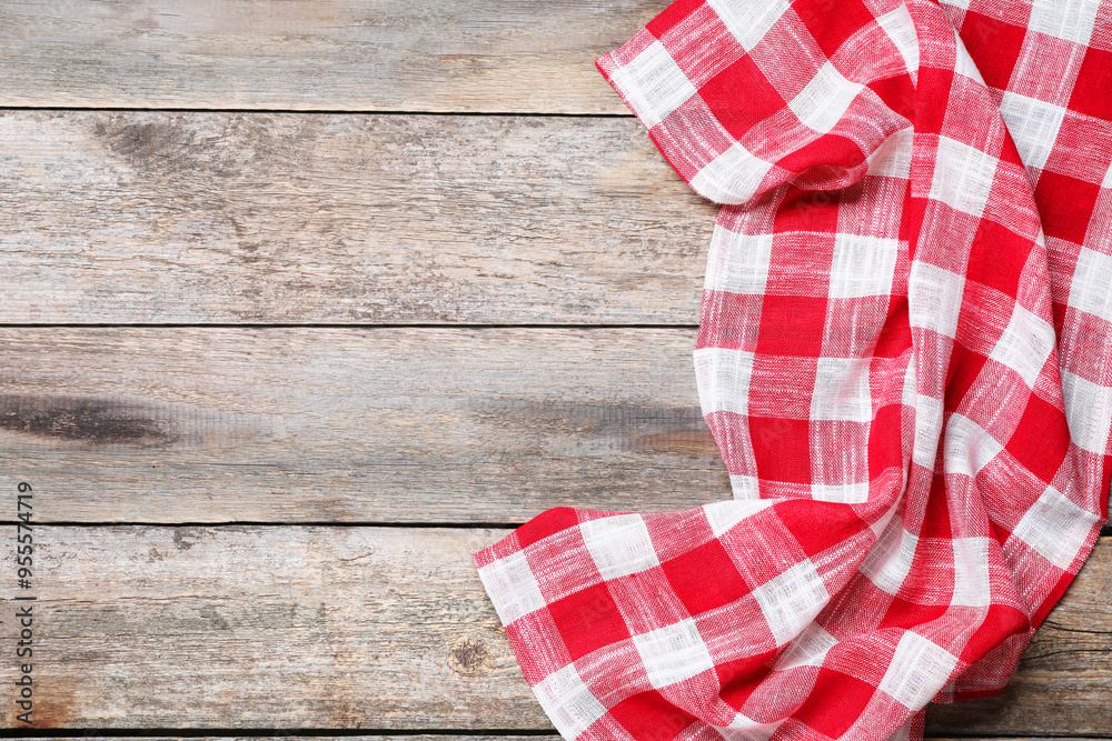 Obraz premium Crumpled tablecloth with checkered pattern on wooden table, top view. Space for text