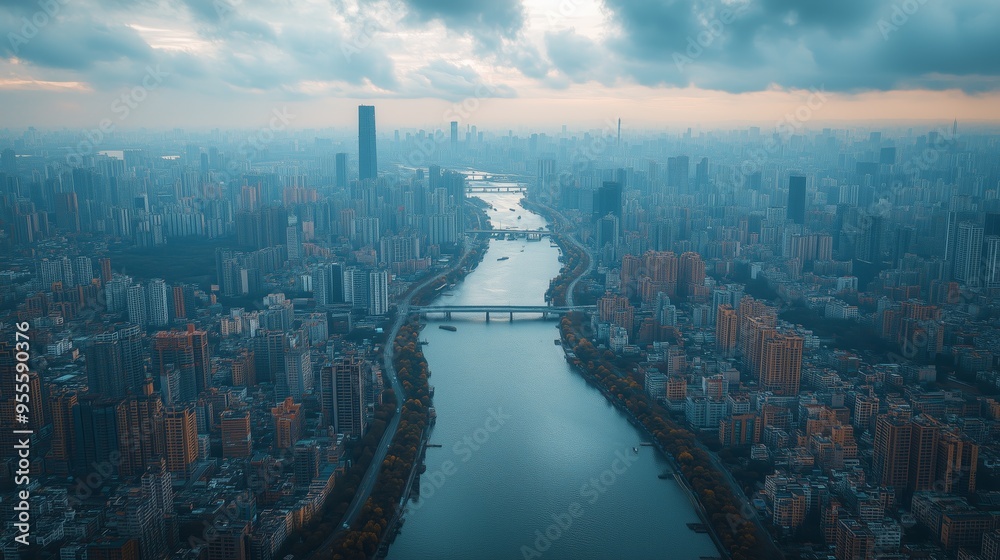 Naklejka premium Modern cityscape with river flowing through center at sunset