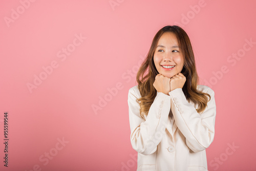 Asian happy portrait beautiful young woman standing smiling surprised excited her keeps hands pressed together under the chin studio shot on pink background with copy space for text