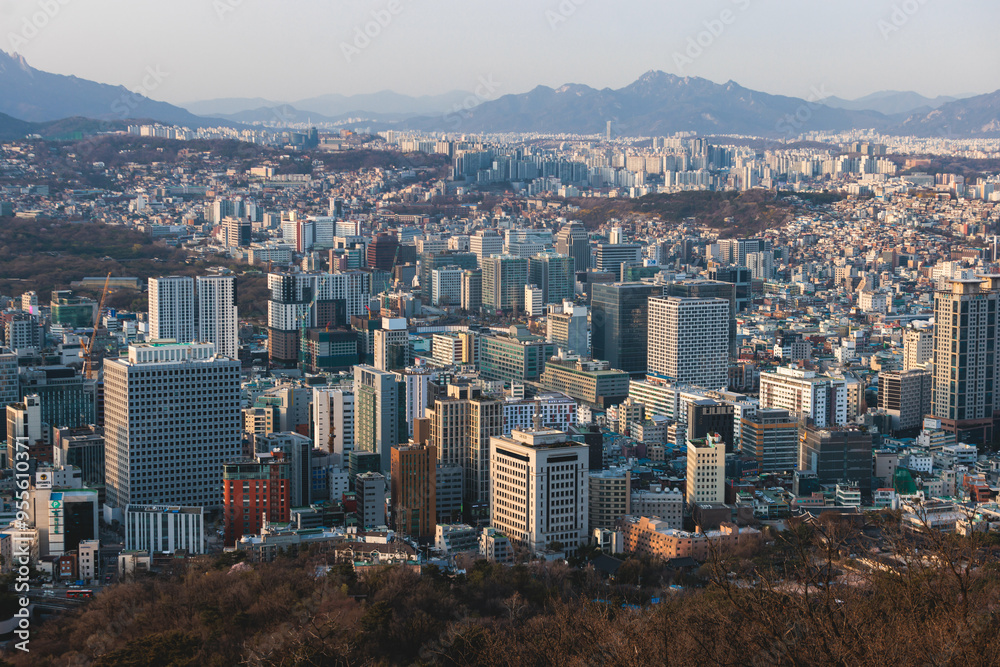 Beautiful vibrant aerial sunset view of Seoul, South Korea skyline, with mountains and sprin scenery beyond the city, seen from observation deck of Namsan Park, Gyeonggi-do province, Republic of Korea Beautiful vibrant aerial sunset view of Seoul, South Korea skyline, with mountains and sprin scenery beyond the city, seen from observation deck of Namsan Park, Gyeonggi-do province, Republic of Korea