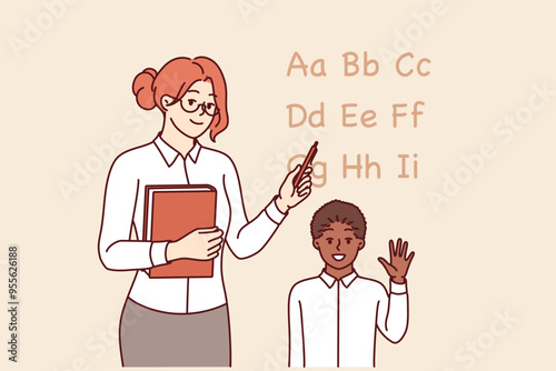 Woman english teacher teaches little boy to read by pointing to letters of alphabet. Girl teacher explains rules of pronunciation and transcription for schoolchild rejoicing in receiving knowledge.