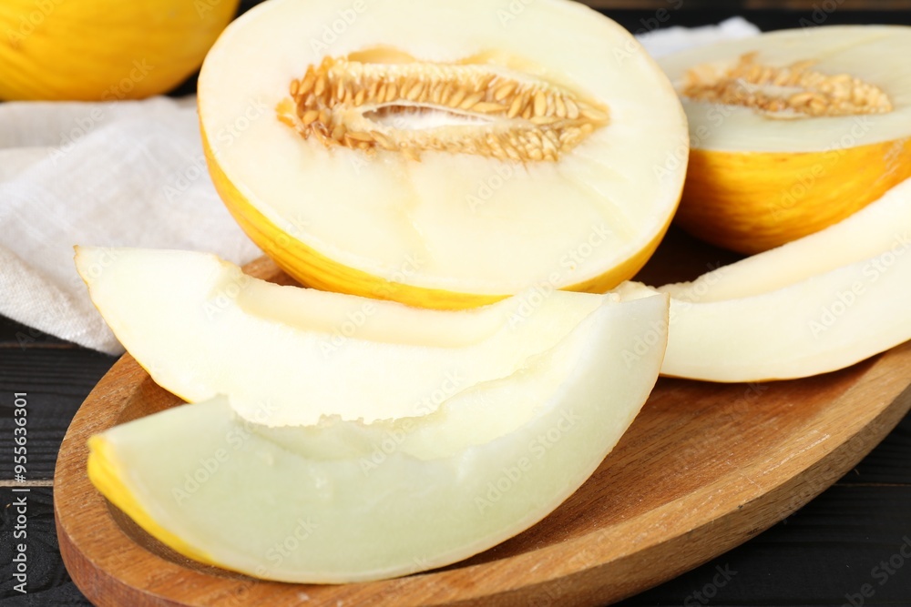 Fresh ripe melons on black wooden table, closeup Fresh ripe melons on black wooden table, closeup