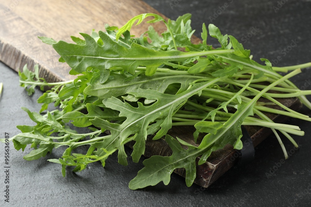 Fresh green arugula leaves on grey textured table, closeup Fresh green arugula leaves on grey textured table, closeup