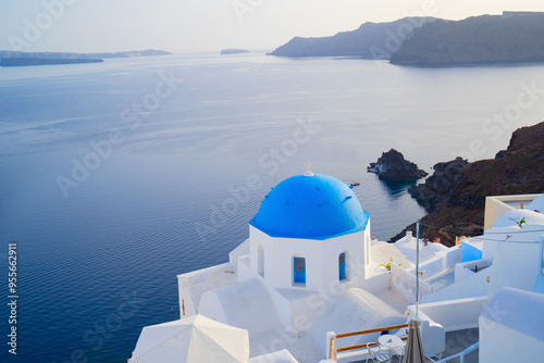 traditional greek village Oia of Santorini, with blue domes of churches and village street, Greece