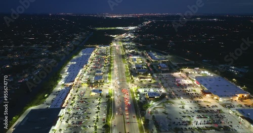 Shopping plaza malls at night with illuminated American road with driving cars in North Port, Florida. View from above of USA retail and transportation infrastructure. photo