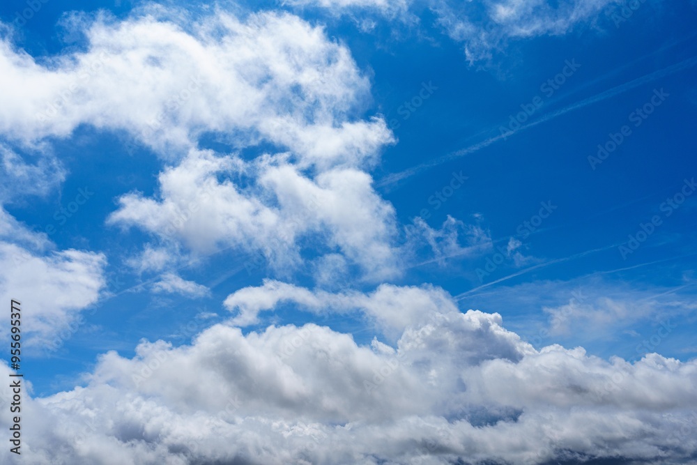 A beautiful blue sky with white fluffy clouds in the background. This scene is perfect for a relaxing day in the park, a picnic with friends, or simply enjoying the serene beauty of nature. A beautiful blue sky with white fluffy clouds in the background. This scene is perfect for a relaxing day in the park, a picnic with friends, or simply enjoying the serene beauty of nature.