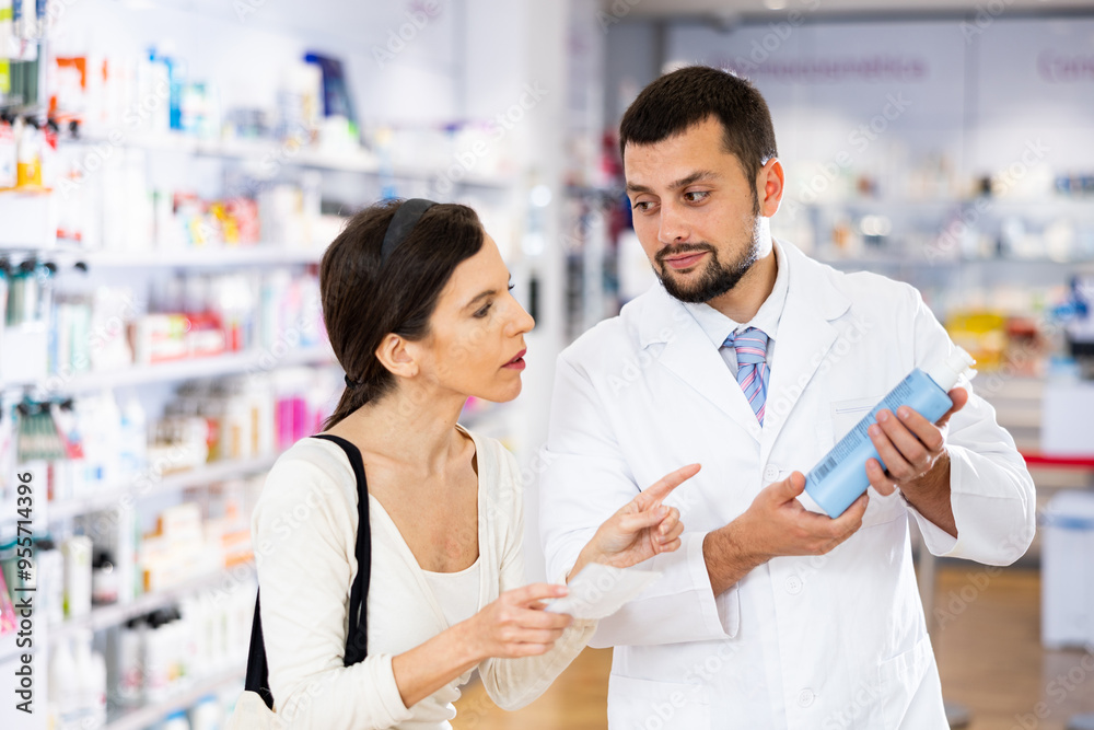 Fototapeta premium Man apothecary giving advise about medicine to woman client.
