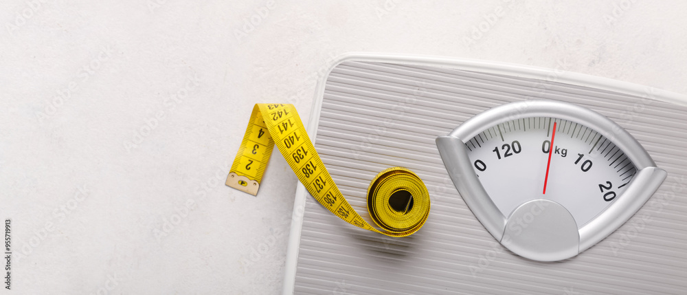 Naklejka premium Scales with yellow measuring tape on white background
