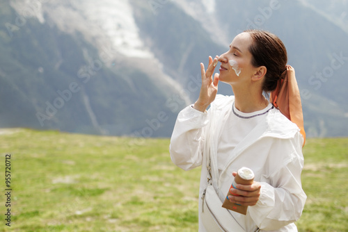 Female Hiker Is Applying Spf Sunscreen To Her Face, Protecting Her Skin From The Sun. Cancer Prevention Concept