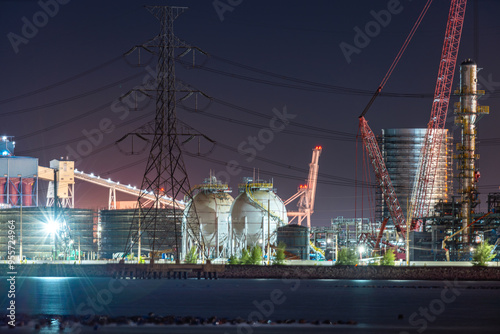 refinery chemical petrochemical plant with LNG tank terminal for petroleum energy fuel industry under crane construction at harbor in industrial area for power energy chemical and transportation busin photo