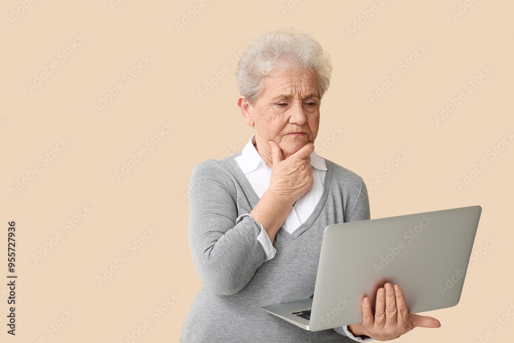 Thoughtful senior woman with laptop on beige background Thoughtful senior woman with laptop on beige background