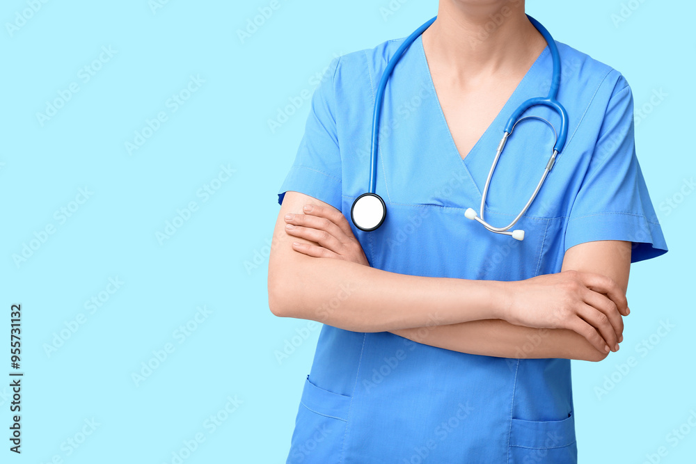 Female doctor in coat with stethoscope on blue background