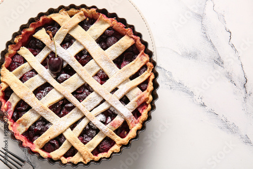 Baking dish with tasty cherry pie on white background