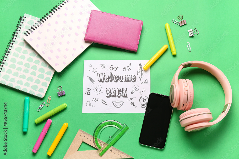 Card with text WELCOME BACK, headphones, stationery and mobile phone on green background Card with text WELCOME BACK, headphones, stationery and mobile phone on green background