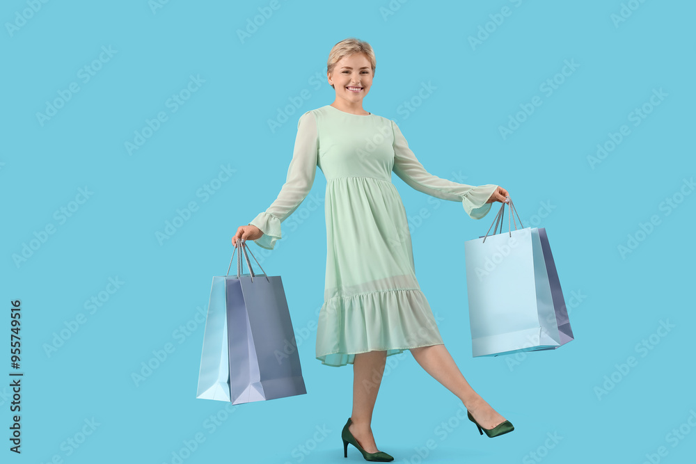 Happy beautiful young woman with shopping bags on blue background Happy beautiful young woman with shopping bags on blue background