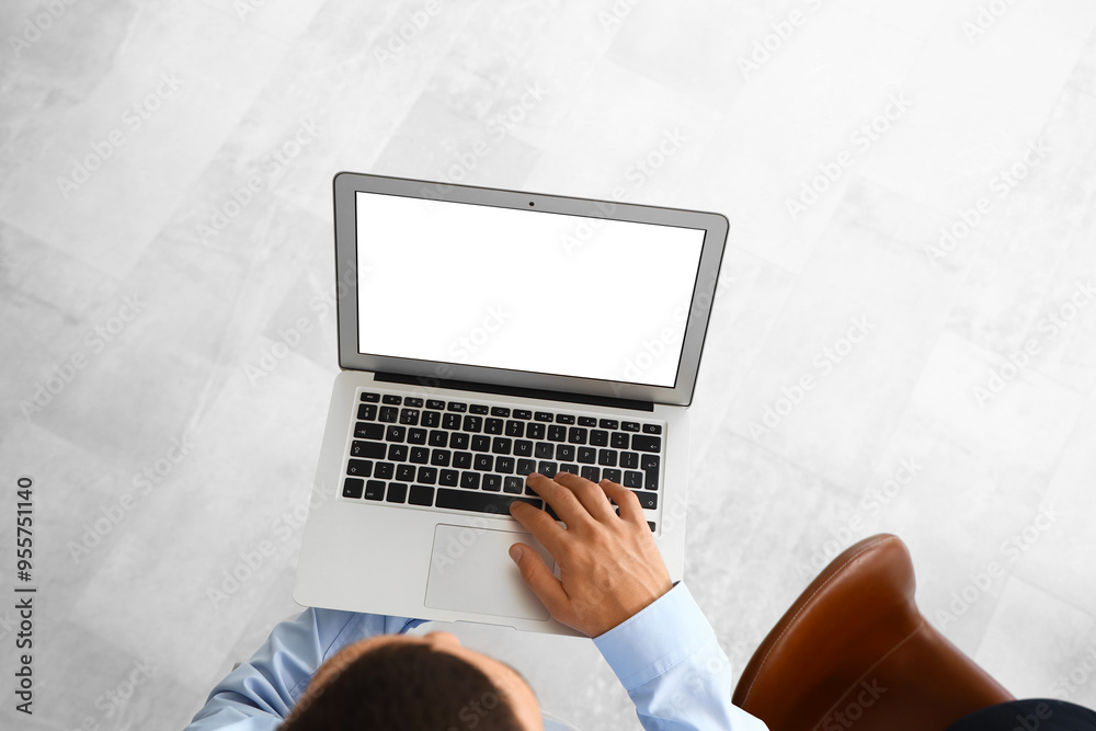 Fototapeta premium Businessman working with laptop in office, top view