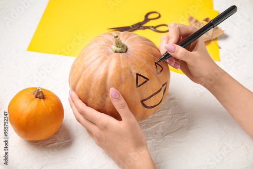 Woman painting pumpkin for ...