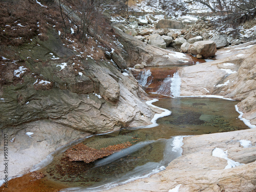 Winter scenery with autumn leaves and ice in small mountain river, nature of Seoraksan National park, Korea 