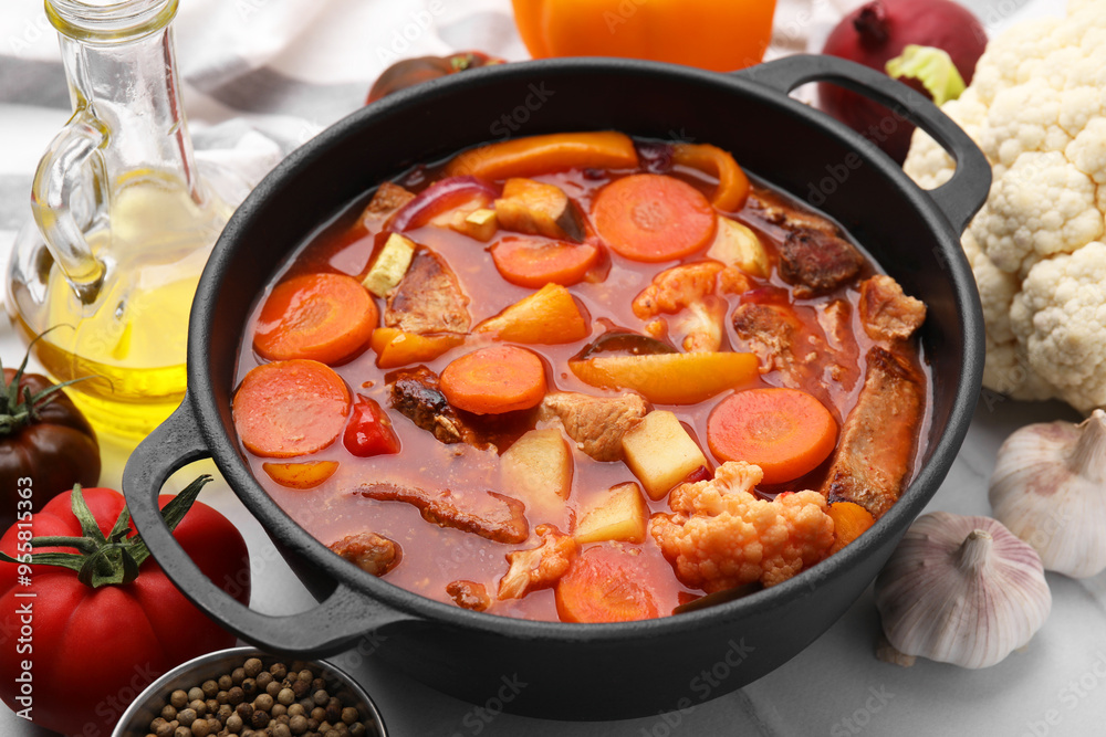 Tasty homemade stew with vegetables on white tiled table, closeup Tasty homemade stew with vegetables on white tiled table, closeup