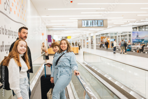 Family riding travelator in airport terminal photo