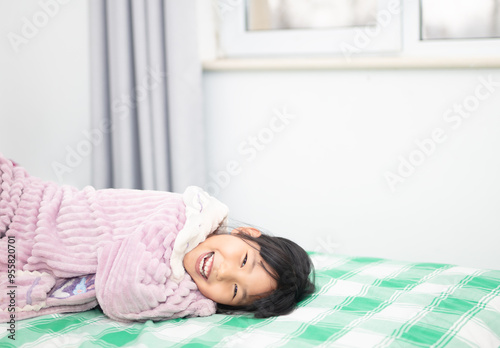 Obraz na płótnie Happy little girl lying on the bed w salonie