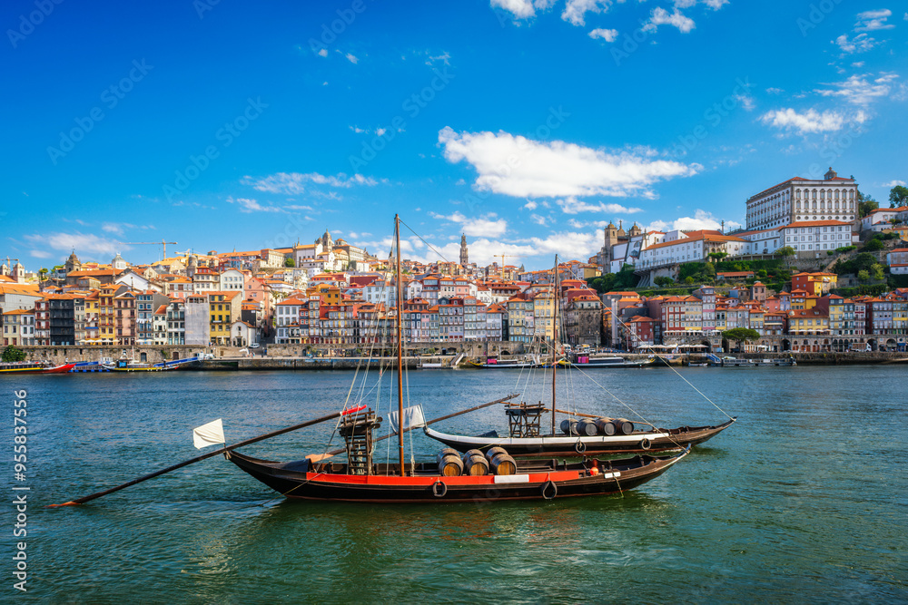 Fototapeta premium View of Porto city and Douro river with traditional boat with port wine barrels from famous tourist viewpoint Marginal de Gaia riverfront. Porto, Vila Nova de Gaia, Portugal