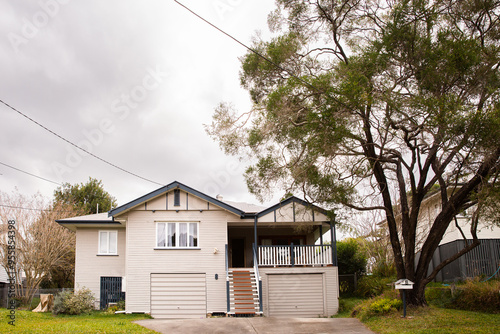 House in suburban Brisbane next to a large tree photo