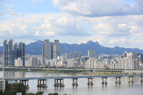 Seongdong-gu, Seoul, South Korea - September 4, 2021: High angle view of Yeongdong Bridge on Han River against highrise apartments and Bukhansan Mountain in the background photo