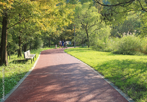 Hwaseong-si, Gyeonggi-do, South Korea - September 11, 2021: Back view of a family walking on the trail of Nojak Park at Dongtan New Town in summer photo