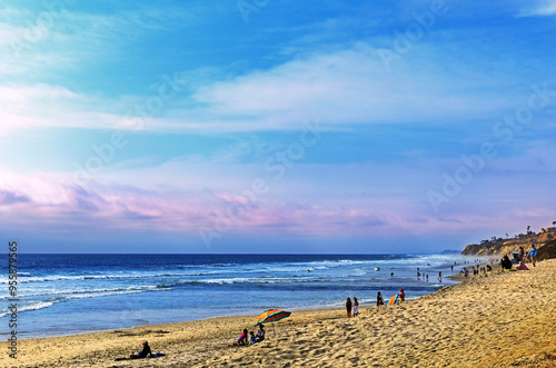 San Diego, California, USA - June 29, 2021: Summer and morning view of tourists on white sand of Del Mar Beach against wave and sea horizon photo