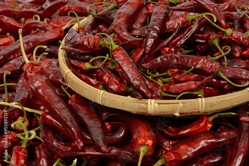 Close-up of stacked dried red Cheongyang Peppers with stems on a bamboo basket, South Korea photo