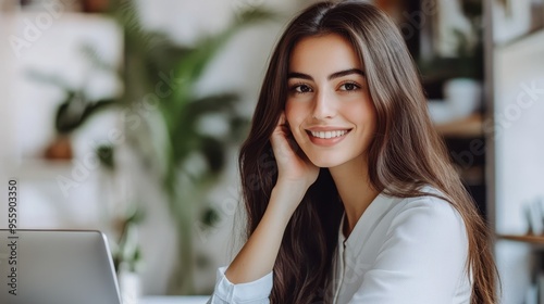 A woman with long hair is smiling and holding a cell phone