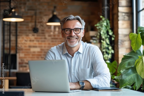 Happy middle aged professional business man, older executive ceo manager, smiling mature entrepreneur wearing glasses and shirt sitting at office desk working on laptop computer. Copy space, ai