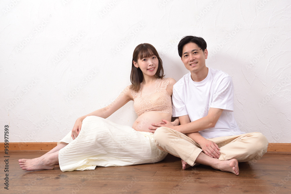 妊娠してお腹の大きな若妻に寄り添う若い夫 妊娠してお腹の大きな若妻に寄り添う若い夫