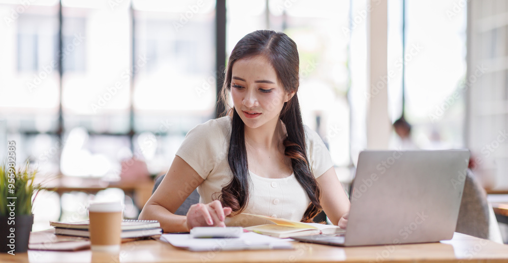 Asian young business woman working on laptop computer reading financial document report in office. Accountant entrepreneur manager businesswoman doing paperwork. Copy space Asian young business woman working on laptop computer reading financial document report in office. Accountant entrepreneur manager businesswoman doing paperwork. Copy space