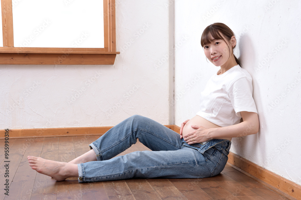 Fototapeta premium 大きなお腹に手を添える若い妊婦
