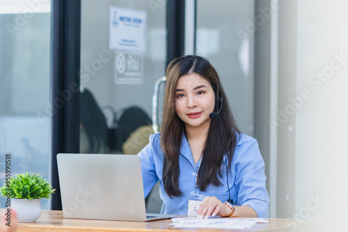 Young asian businesswoman with headset using desktop computer for customer support and online working in office, Call center helping for customers online concept.