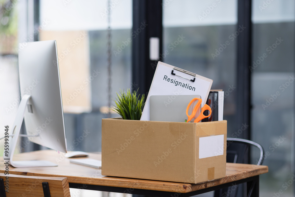 a storage box on office desk, employee being fired from her work concept. a storage box on office desk, employee being fired from her work concept.