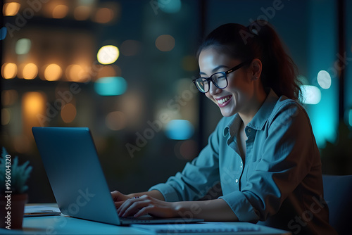 a woman sits at a laptop in the office