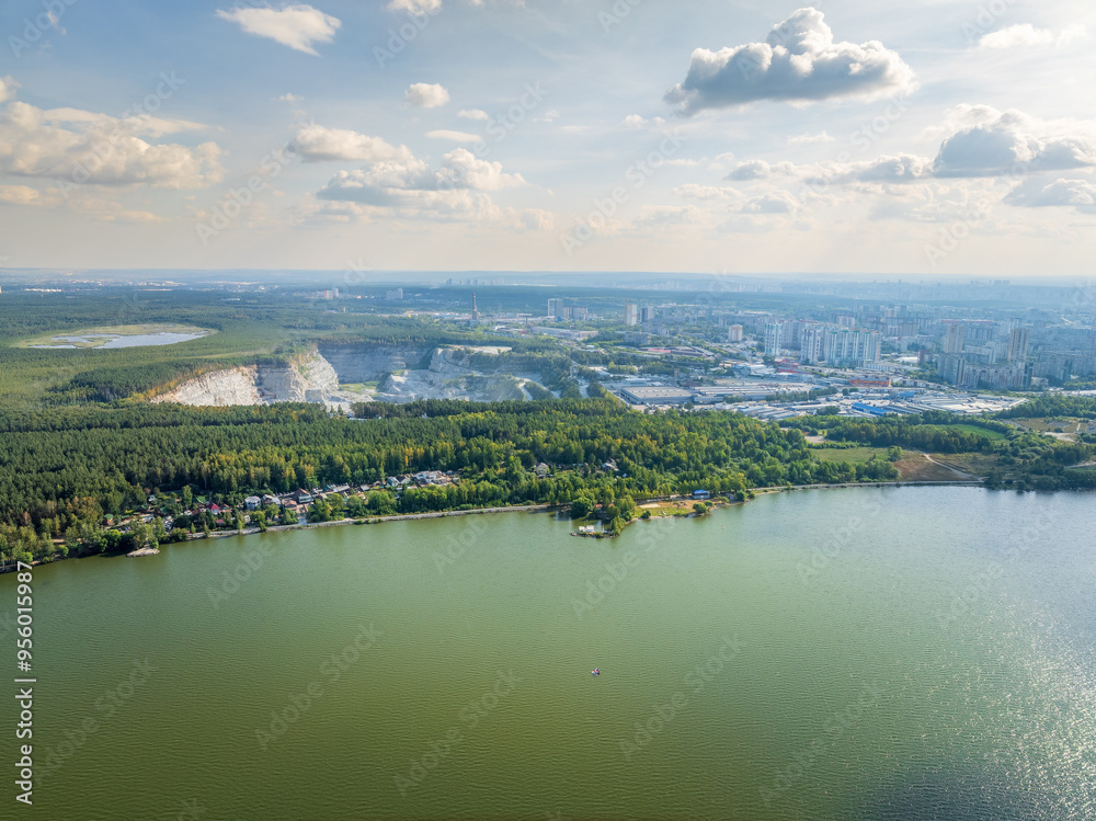 Fototapeta premium Stone quarry in the forest. Flying over the summer mixed forest during sunset. The surroundings of Yekaterinburg. Ural, Russia, Aerial View