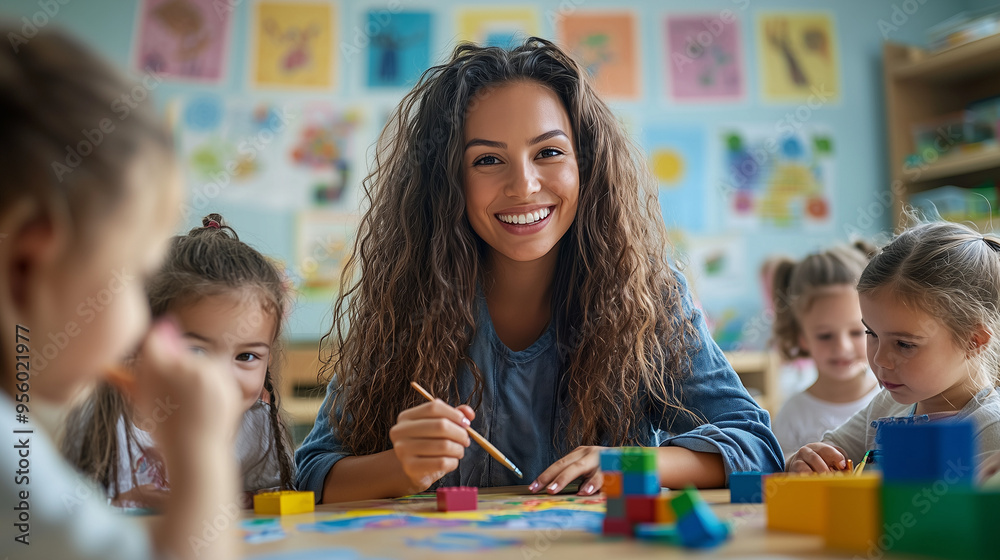 Fototapeta premium A kindergarten classroom decorated with colorful posters and drawings, young children painting and building with blocks, a teacher assisting them with a smile