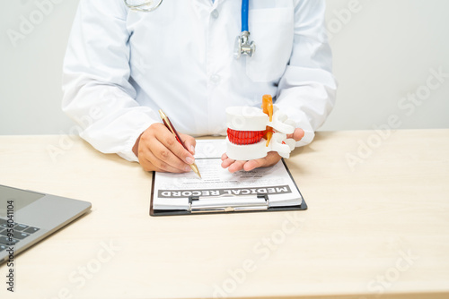 A female doctor sits at a table in a hospital, discussing spine conditions like scoliosis,lumbar disc herniation, degenerative spine disease,and spinal fractures,highlighting risks such as paralysis photo