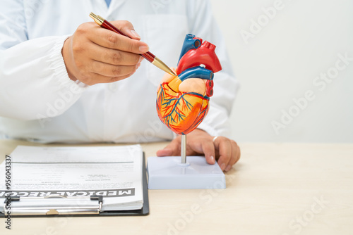 A female doctor works at a desk in the hospital,discussing heart diseases such as coronary artery disease,arrhythmia,heart valve stenosis,heart failure congenital heart disease, emphasizing symptoms photo