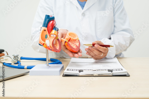 A female doctor works at a desk in the hospital,discussing heart diseases such as coronary artery disease,arrhythmia,heart valve stenosis,heart failure congenital heart disease, emphasizing symptoms photo